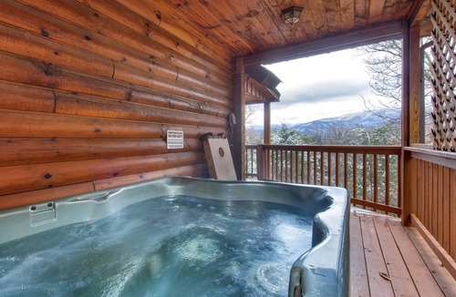 Gatlinburg Cabin | Pet-friendly retreat with tree-top views, a hot tub + an arcade loft!
