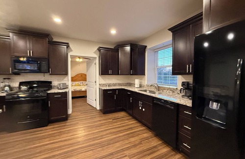 Caseyville Apartment | Private one-bedroom suite with king bed, walk-in closet, and ensuite bath featuring double vanity and safety grab bars. Enjoy serene pond views from your patio, full kitchen, and dedicated workspace for a comfortable stay.