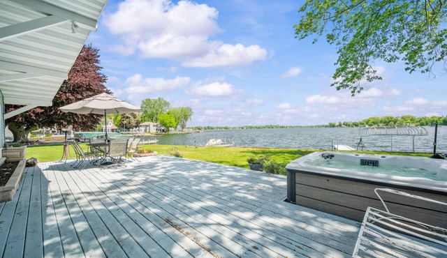 Wake up to sunrise views over Paw Paw Lake at this cozy lakefront cottage with a dock, hot tub, and room for 8.